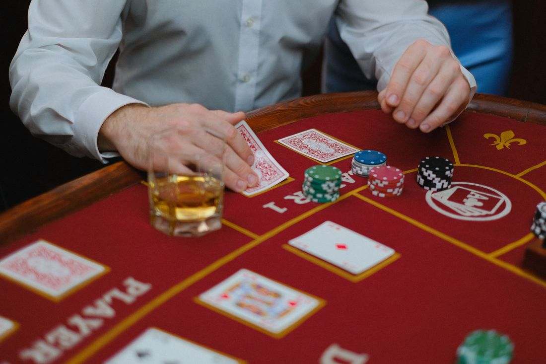 Meja poker dengan kartu terbuka dan tumpukan chip merah
