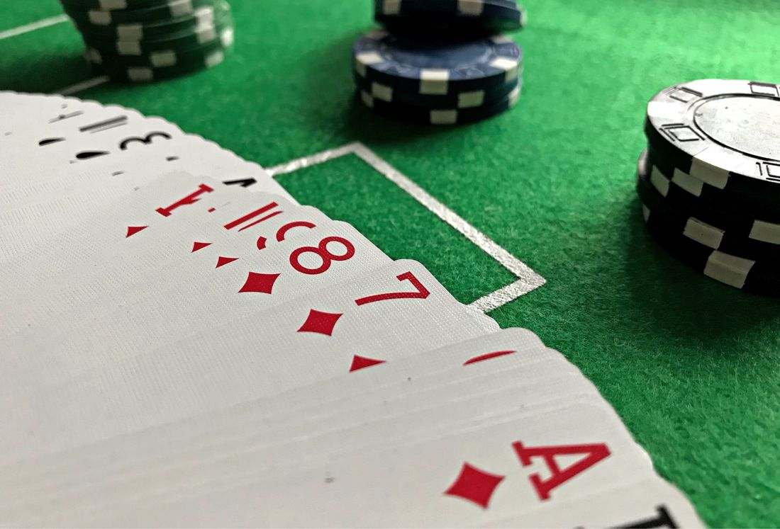 Kartu poker dan chip di atas kain meja hijau