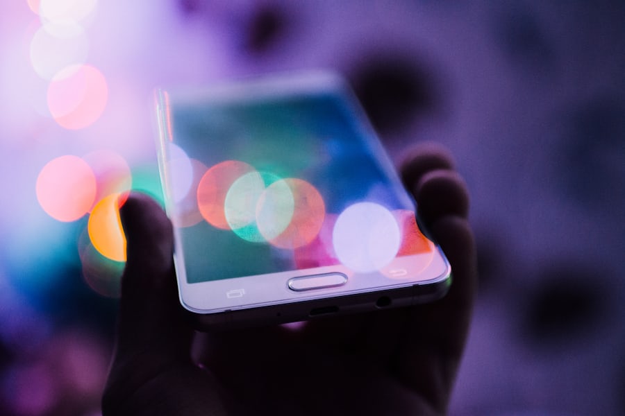 Tangan memegang ponsel dengan tampilan situs mobile
